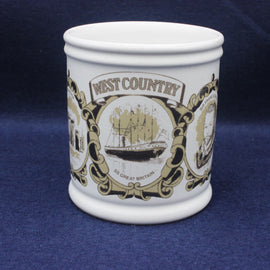 White mug with decorative black and gold design on a blue background