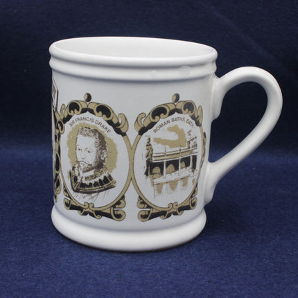 White mug with gold and black designs on a blue background