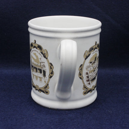White mug with gold decorative patterns on a dark blue background