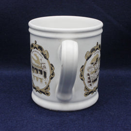 White mug with gold decorative patterns on a dark blue background