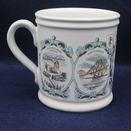 White mug with decorative designs of Eilean Donan Castle and Forth Bridge on a blue background