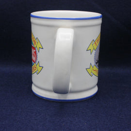 White mug with colorful graphics on a dark blue background