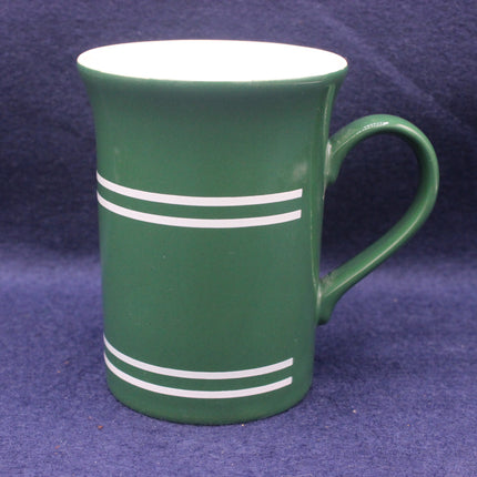 Green mug with white stripes on a purple background
