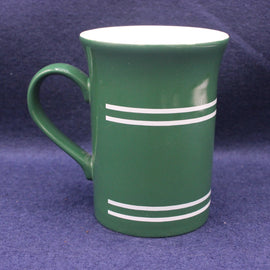 Green mug with white stripes on a purple background