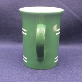 Green mug with white stripes on a blue background