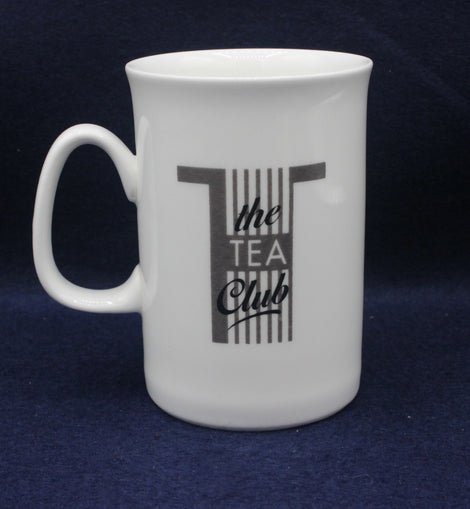 White mug with 'the TEA Club' text on a dark blue background