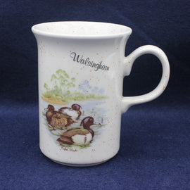 White mug with duck design and 'Walsingham' text on a blue background