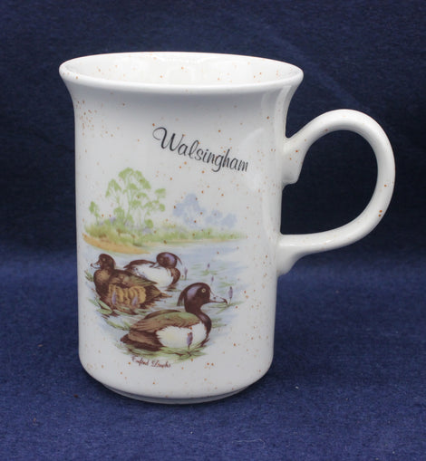White mug with duck design and 'Walsingham' text on a blue background
