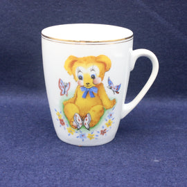 White mug with a teddy bear design on a blue background
