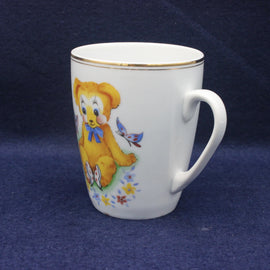 White mug with a colorful teddy bear design on a blue background