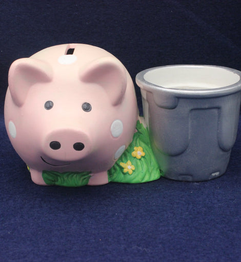 Pink piggy bank with a gray cup on a blue background