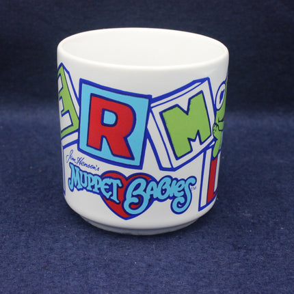 White mug with colorful text design on a dark blue background