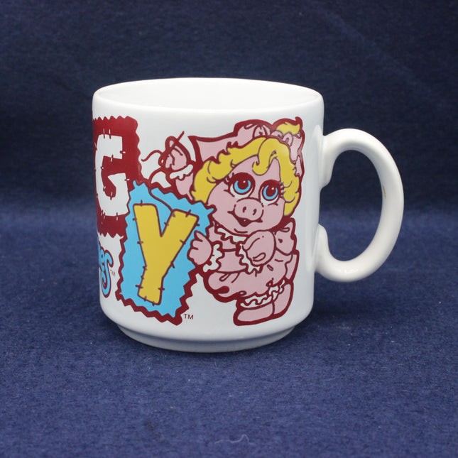 White mug with colorful design of a cartoon character and text on a blue background
