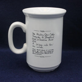 White mug with black text on a dark blue background