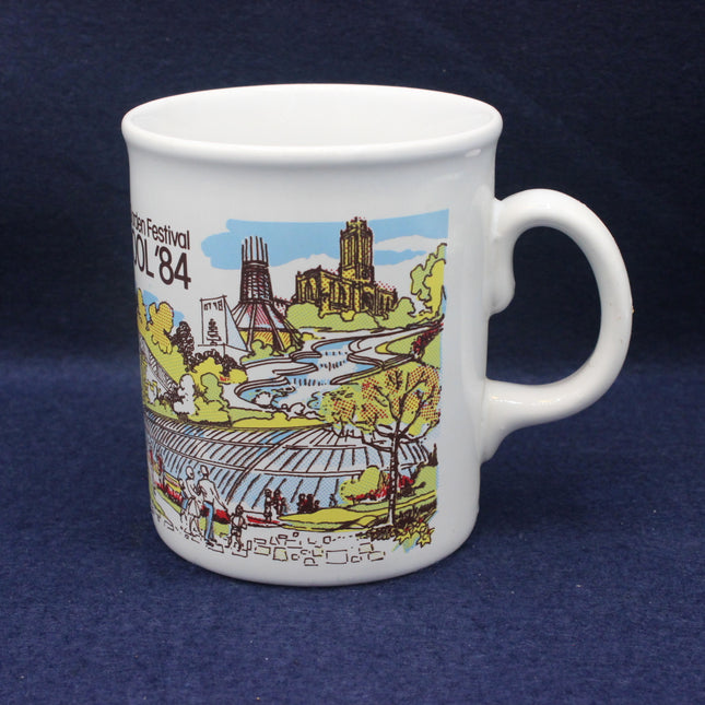 White mug with a colorful design of a festival scene on a dark blue background