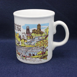 White mug with a colorful design of a festival scene on a dark blue background
