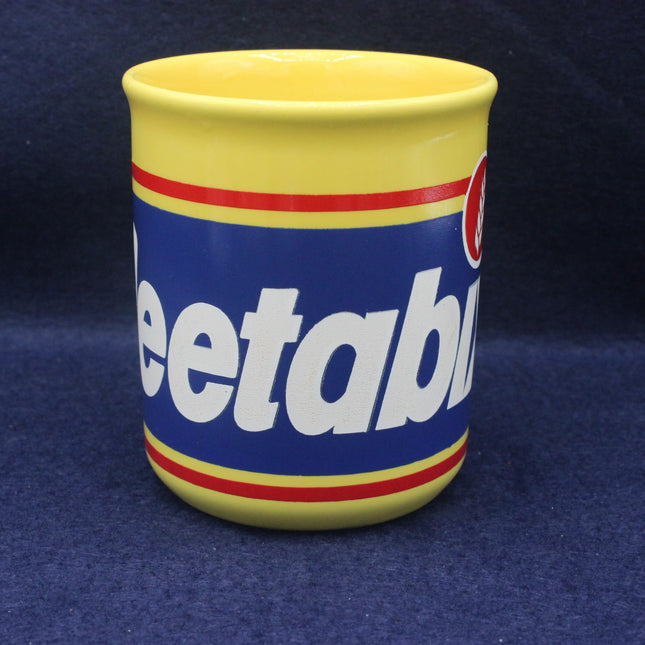Yellow mug with blue and red design featuring the word 'Weetabix' on a dark blue background