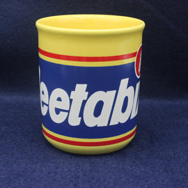 Yellow mug with blue and red design featuring the word 'Weetabix' on a dark blue background