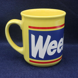 Yellow mug with a blue label featuring the word 'Weetabix' on a dark blue background