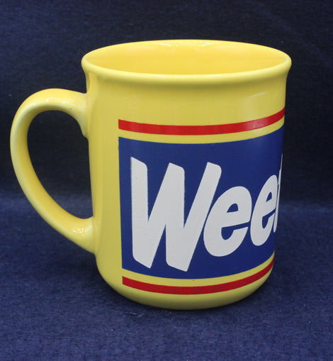 Yellow mug with a blue label featuring the word 'Weetabix' on a dark blue background