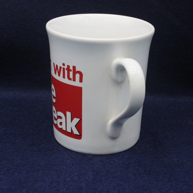 White mug with a red and black label on a dark blue background