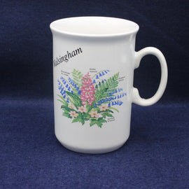 White mug with floral design and 'Walsingham' text on a blue background