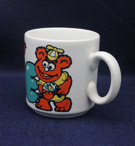 White mug with a colorful cartoon character Fonz on a dark blue background