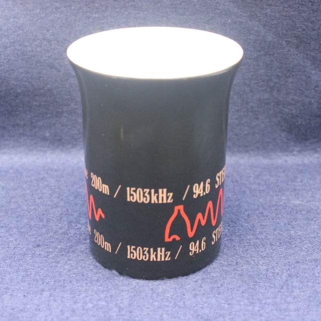 Black beaker with red text and measurements on a blue background
