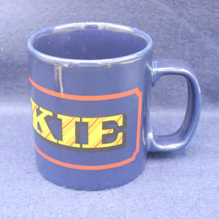 Blue mug with colorful text on a gray background