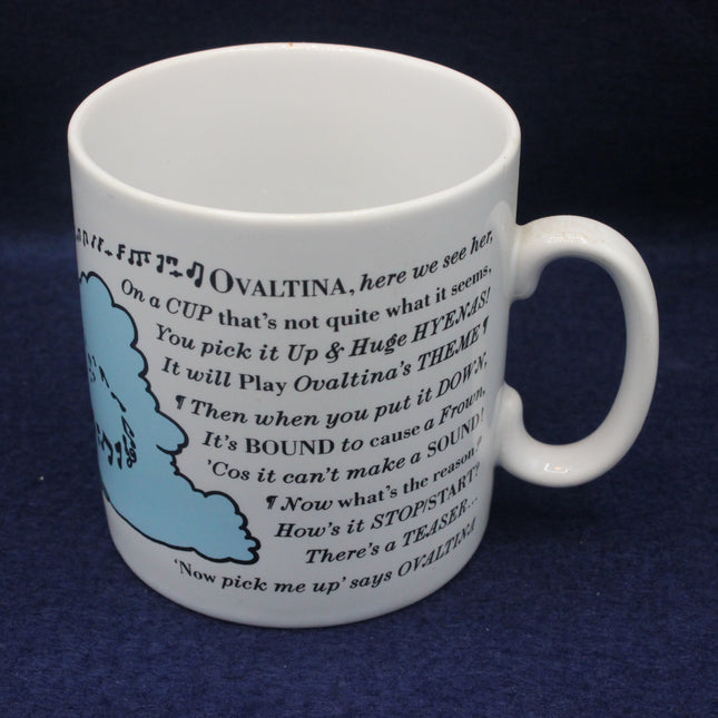 White mug with text and blue illustration on a dark background