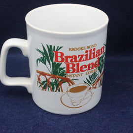 White mug with Brooke Bond Brazilian Blend instant coffee branding on a dark blue background