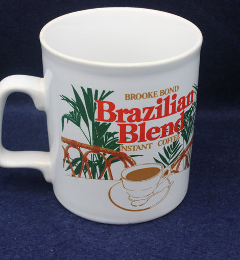 White mug with Brooke Bond Brazilian Blend instant coffee branding on a dark blue background