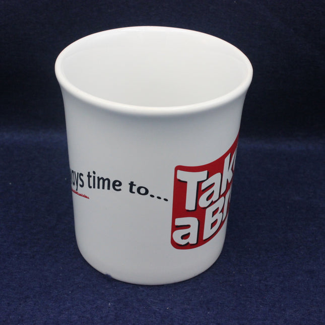 White cup with red and black text on a dark blue background