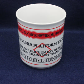 White mug with red and black text on a blue background