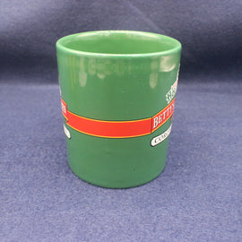 Green ceramic cup with a red band featuring text on a blue background