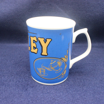 Blue mug with yellow text and design on a blue background