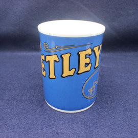 Blue mug with yellow text on a dark blue background