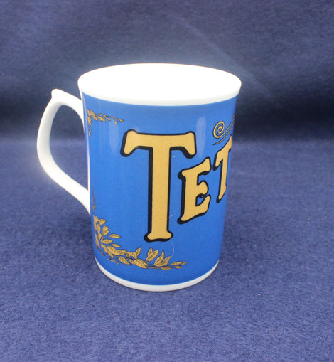 Blue mug with gold lettering on a blue background