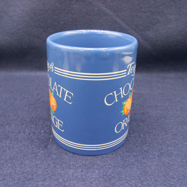 Blue mug with text and orange illustrations on a dark background
