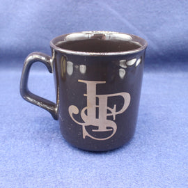 Black mug with JPS logo on a blue background
