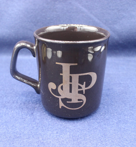 Black mug with JPS logo on a blue background