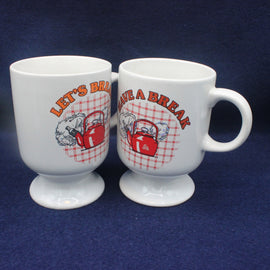Two white mugs with red and orange graphics and text on a blue background