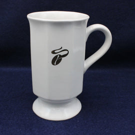 White mug with a gold coffee bean design on a dark blue background