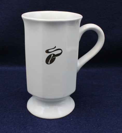 White mug with a gold coffee bean design on a dark blue background