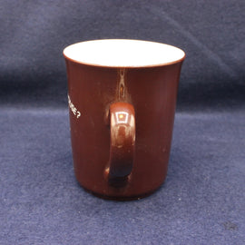Brown mug with a white interior on a dark blue background