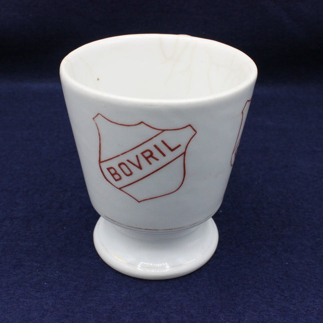 White ceramic cup with red 'BOVRIL' logo on a blue background