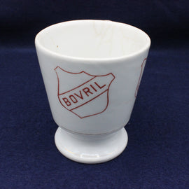 White ceramic cup with red 'BOVRIL' logo on a blue background