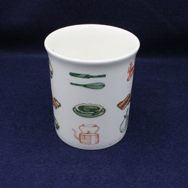 White ceramic cup with colorful illustrations on a dark blue background