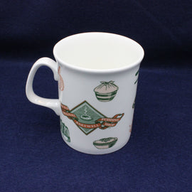 White mug with green and red graphics on a dark blue background