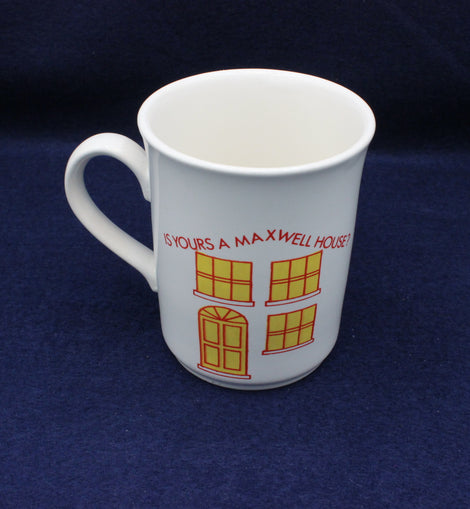 White mug with yellow house design and red text on a dark blue background